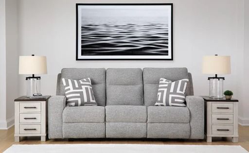 Gray reclining sofa between two nightstands, under a water-themed artwork.