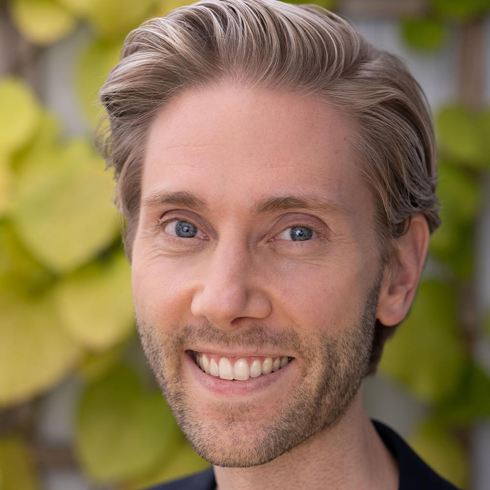 Ein Mann mit Bart lächelt in die Kamera