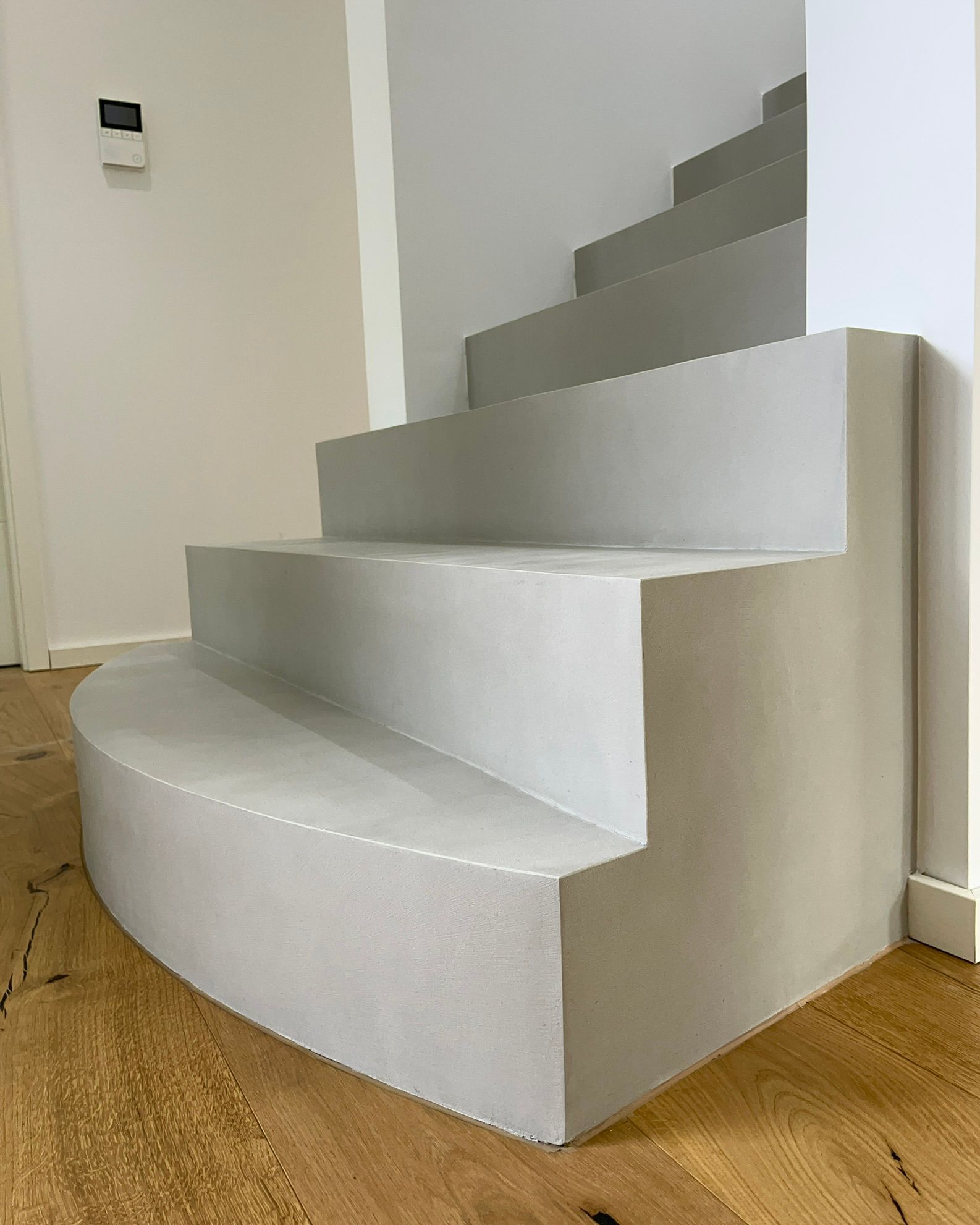 Eine Betontreppe wurde in einem Wohnhaus mit Mikrozement Fugenlos in Betongrau beschichtet und verschönert