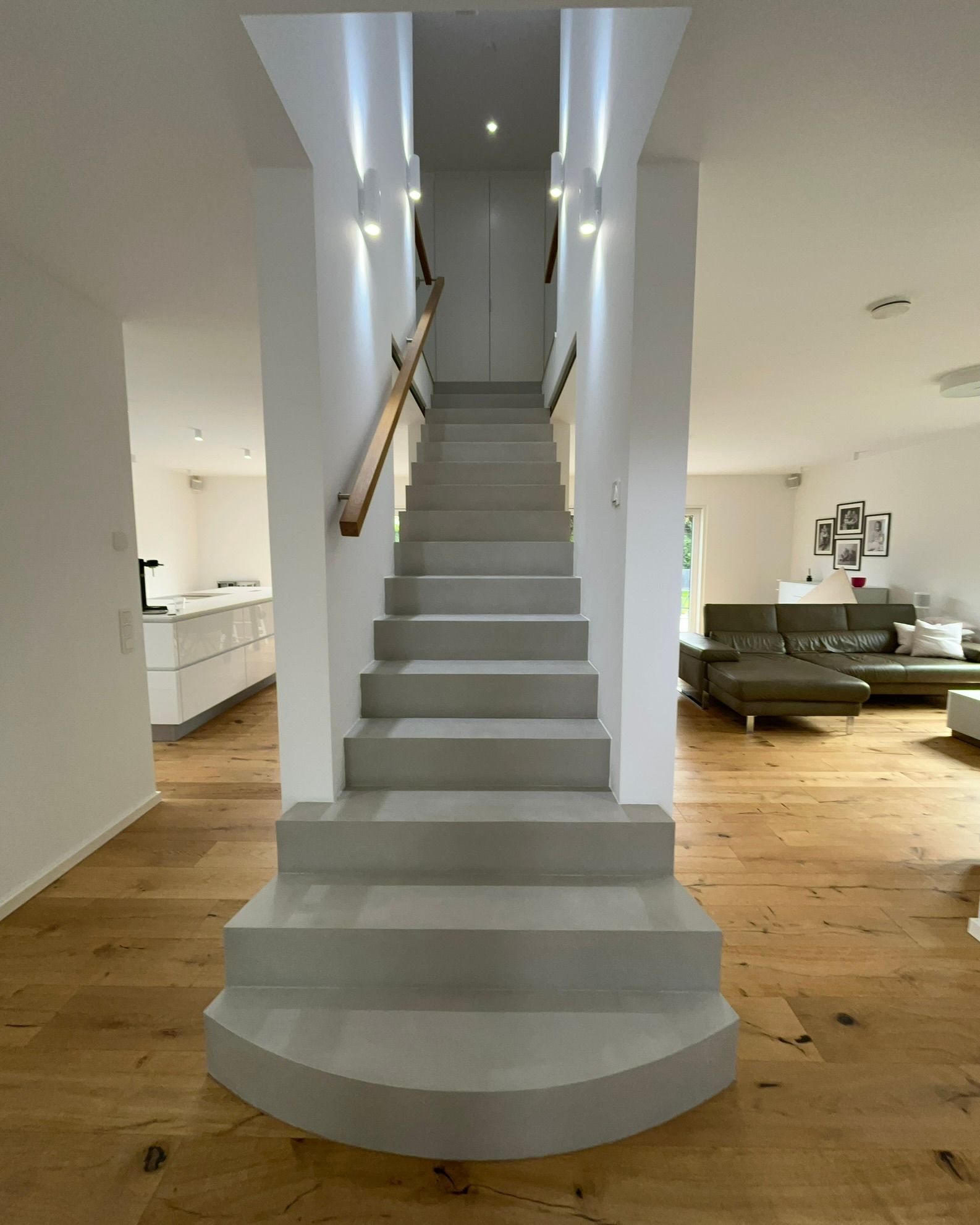 Betontreppe beschichtet mit Beton Ciré in einem Wohnhaus zentral als eyecatcher zwischen Wohnbereich und Küche