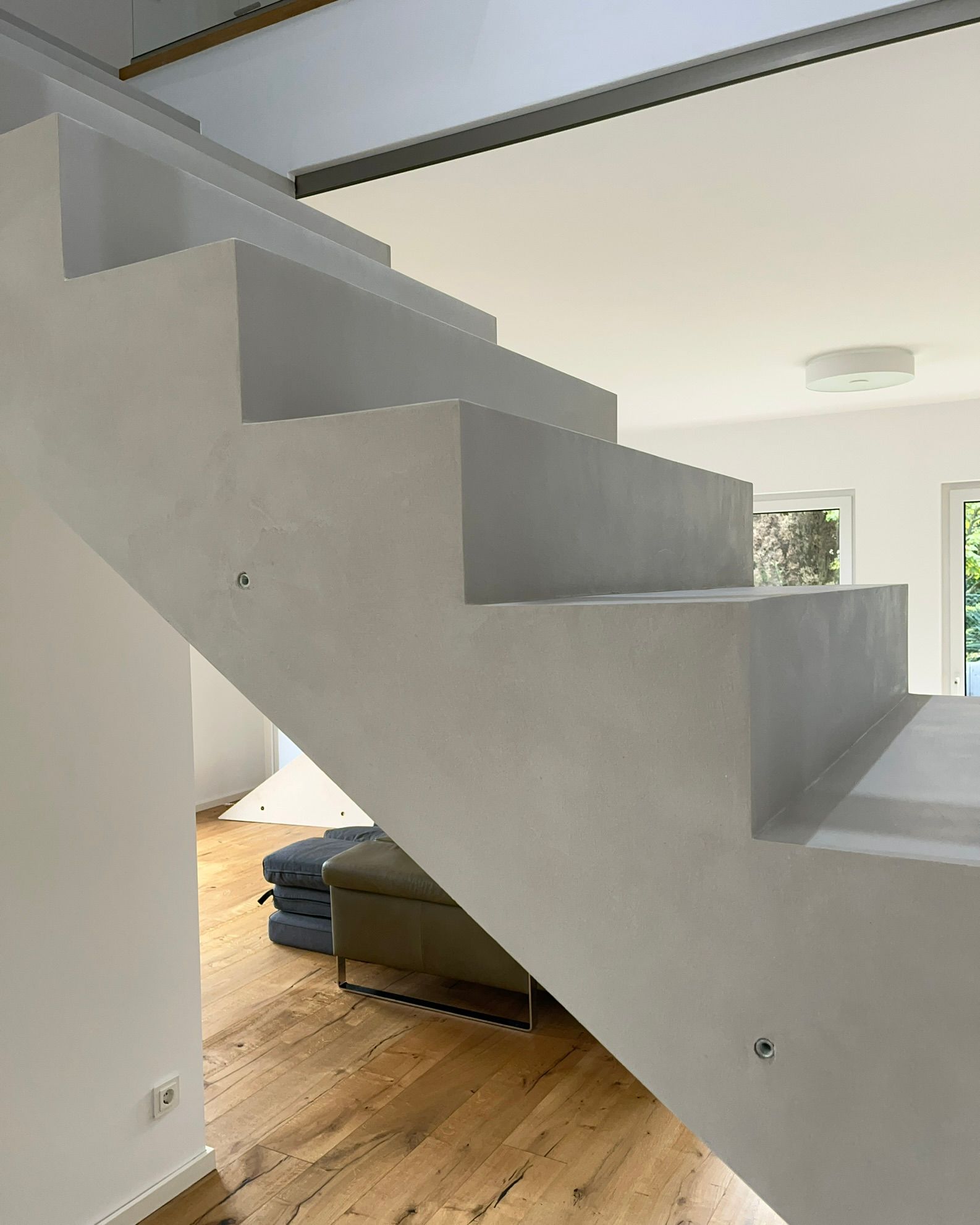 Eine Betontreppe wurde in einem Wohnhaus mit Mikrozement Fugenlos in Betongrau beschichtet und verschönert