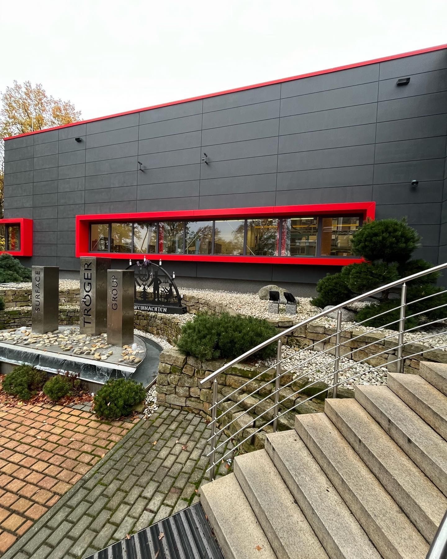 Sichtbetonfassade eines Geschäftshauses im Farbton Anthrazit verschönert mit Betonkosmetik und imprägniert mit PolySealer der Firma rauMKult Sichtbeton