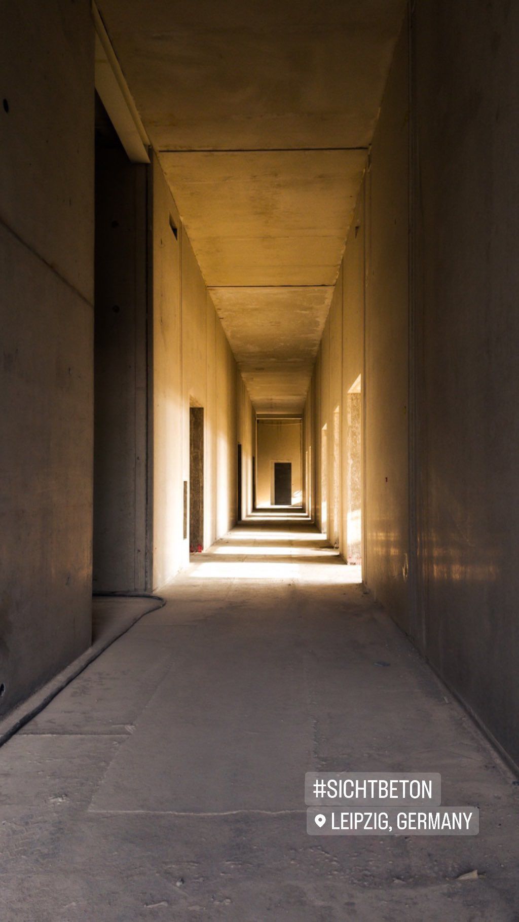 Sichtbeton langer Flur durchflutet mit Sonne