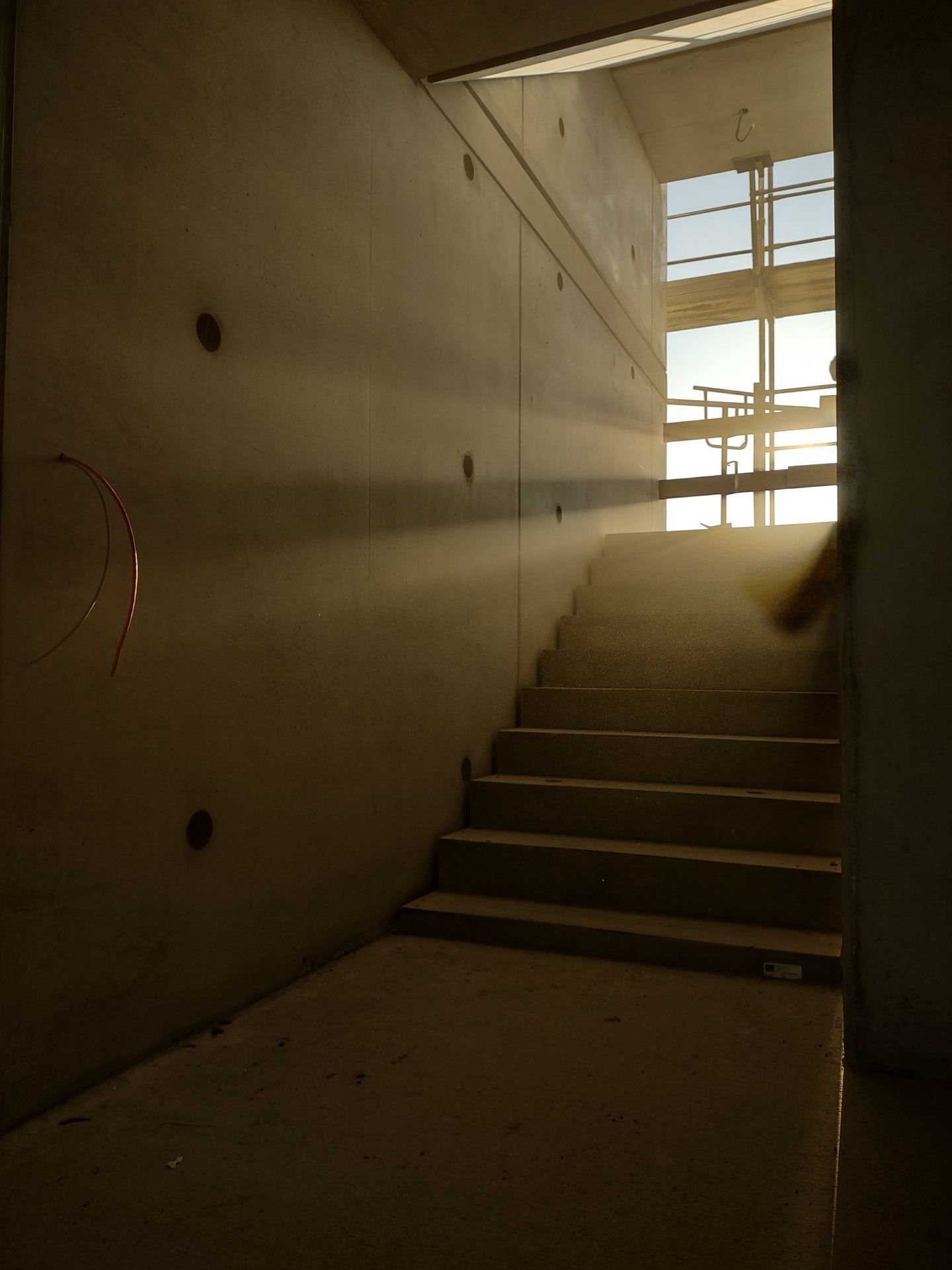 Betonwand in einem Sichtbeton Treppenhaus wird mit Abendsonne durchflutet