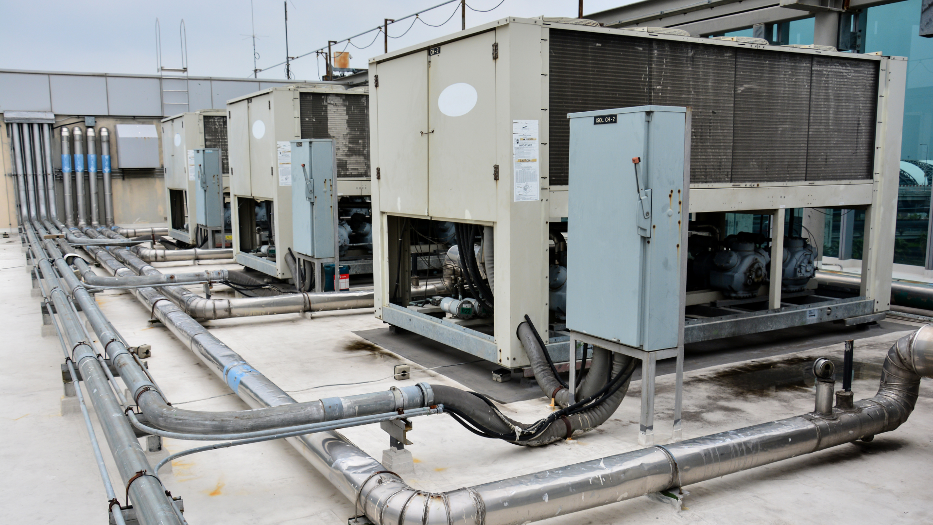 A row of air conditioners are sitting on top of a building.