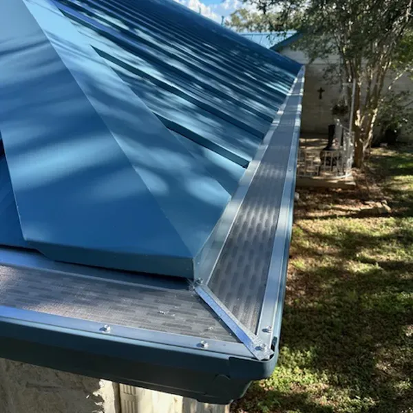 Blue metal roof with gutter guard system installed.