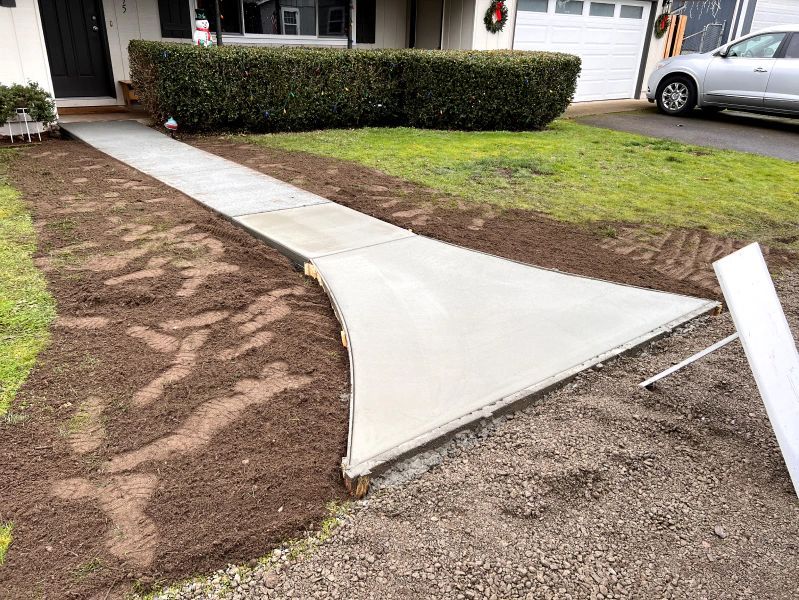 A concrete walkway is being built in front of a house.