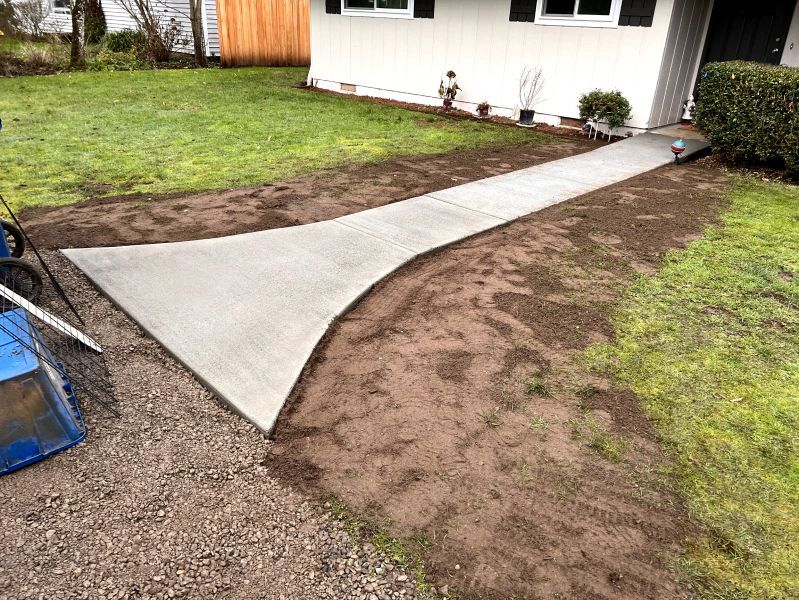 A concrete walkway is being built in front of a house.