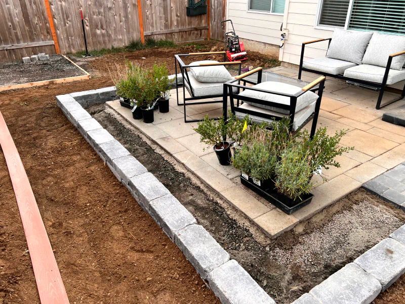 A patio with a couch , chairs , and potted plants.