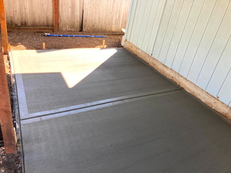 A concrete walkway is being built in front of a house.