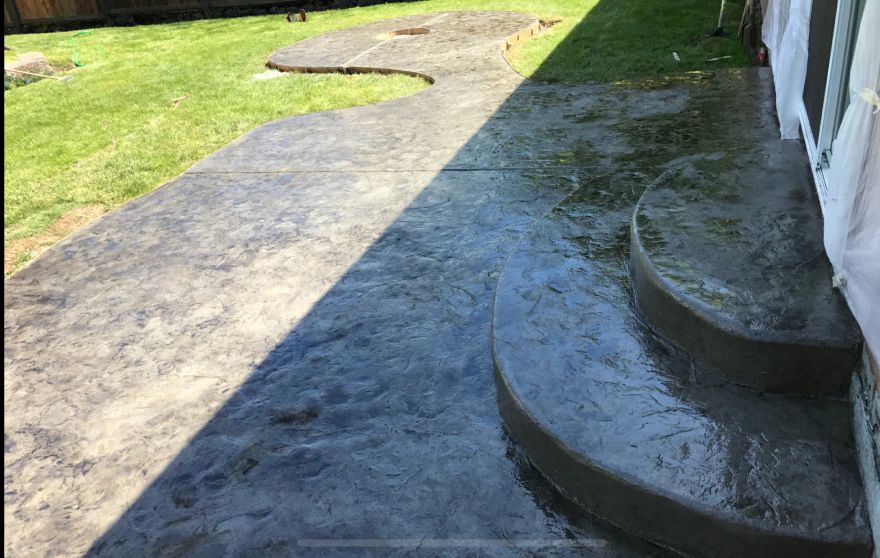 A concrete walkway with steps leading up to a house.