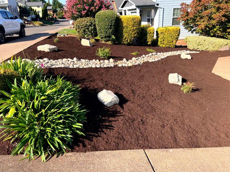 A white truck is parked in front of a lush green garden.
