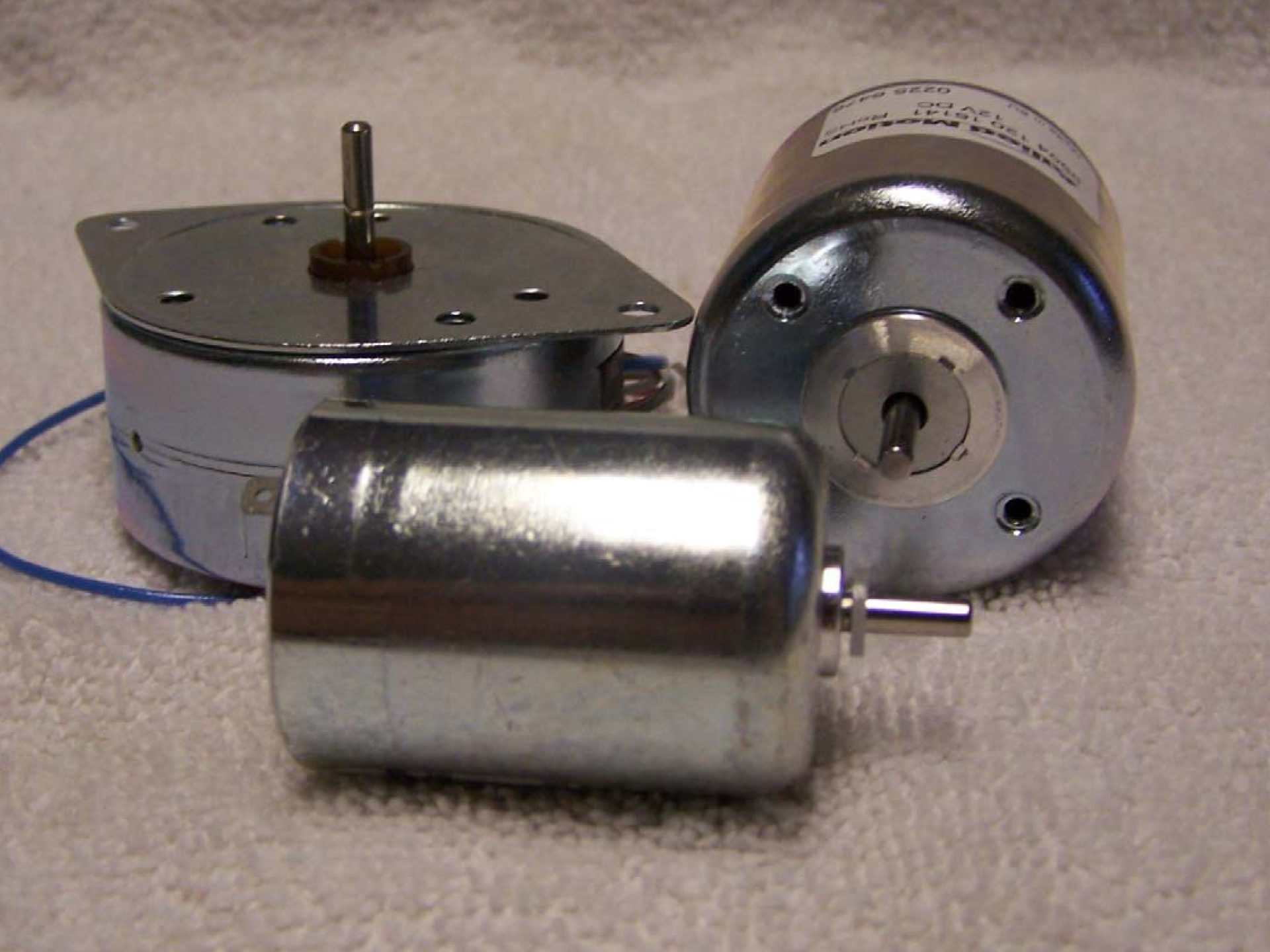 Three different types of starter motors are sitting on a table.