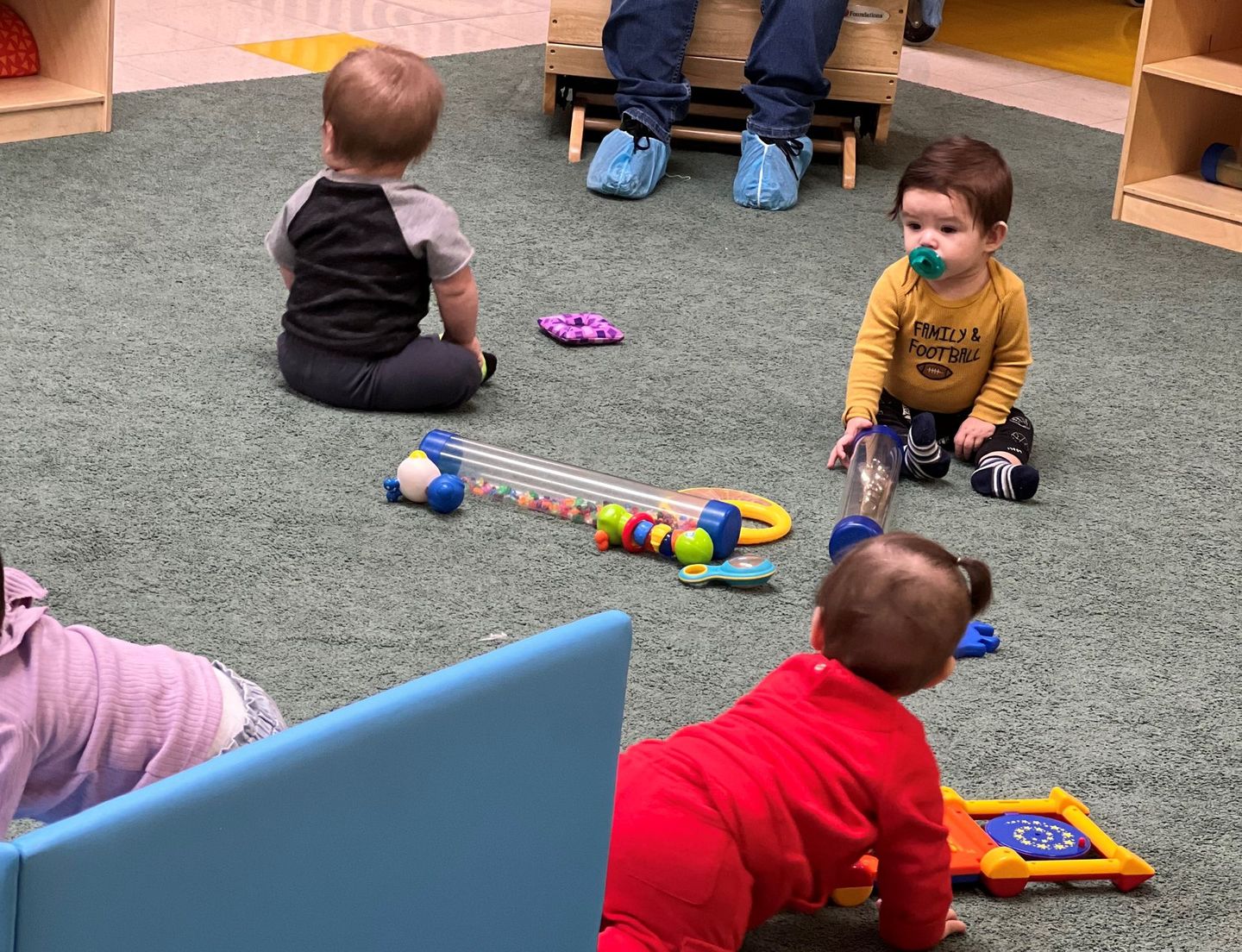 a group of babies are playing with toys on the floor .