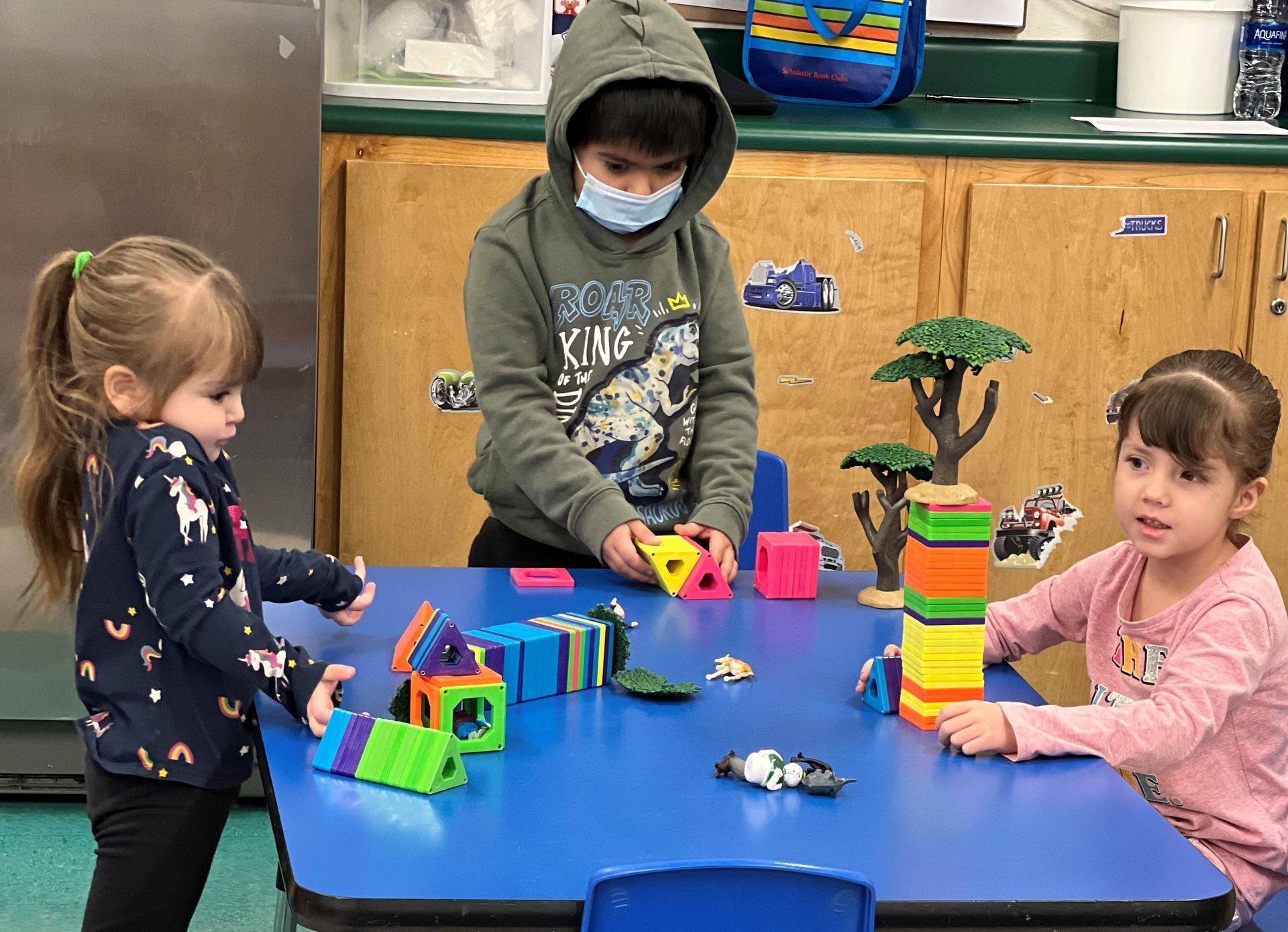 a group of children are playing with blocks at a table .