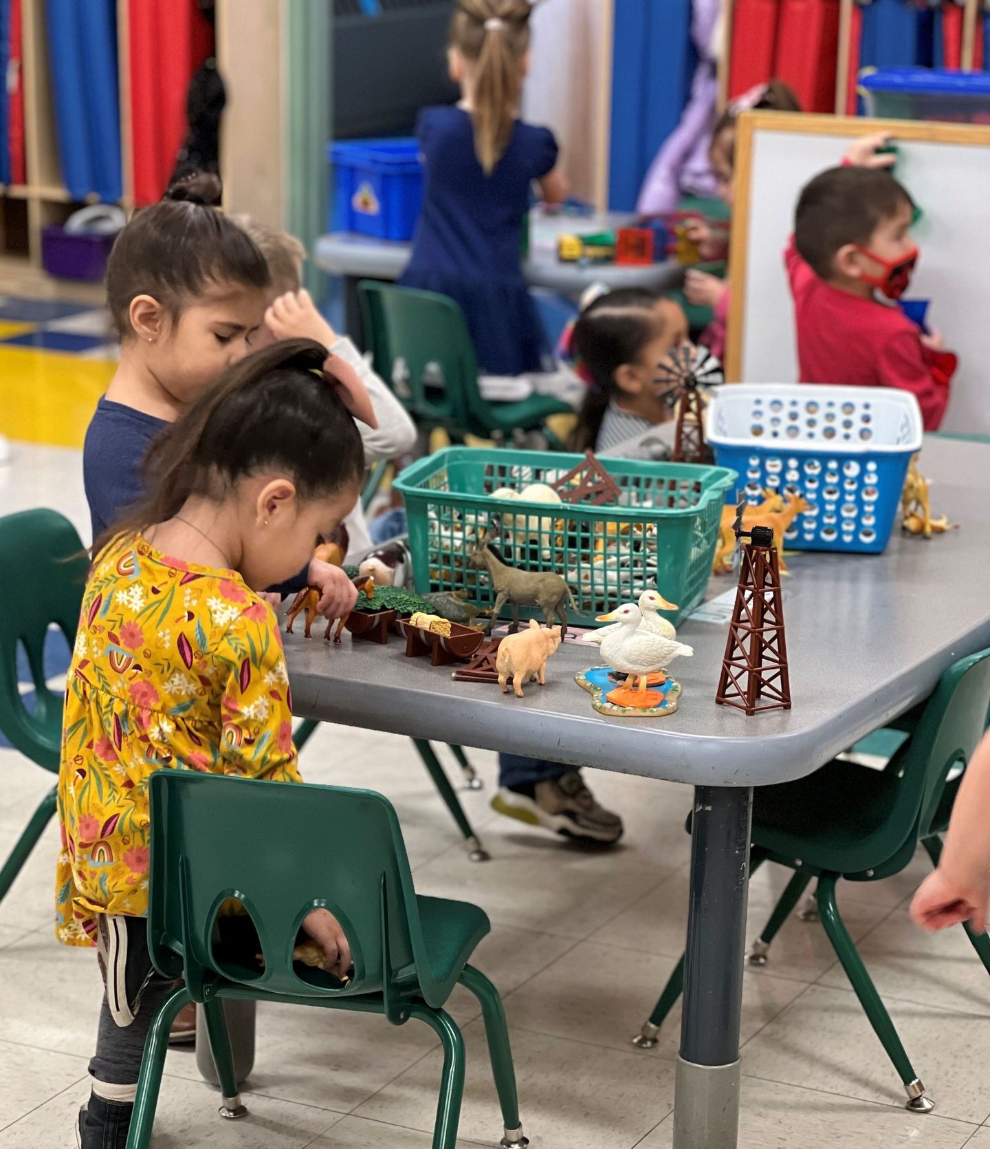a group of children are playing with toys at a table