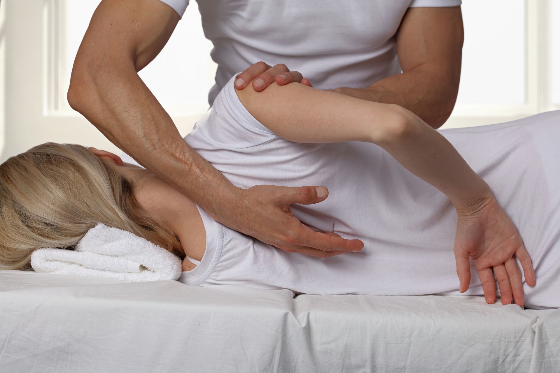 Chiropractor performing a side lying spinal adjustment to support lower back alignment.