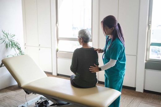 Chiropractic exam for senior with back pain, osteopathy & physical therapy care.