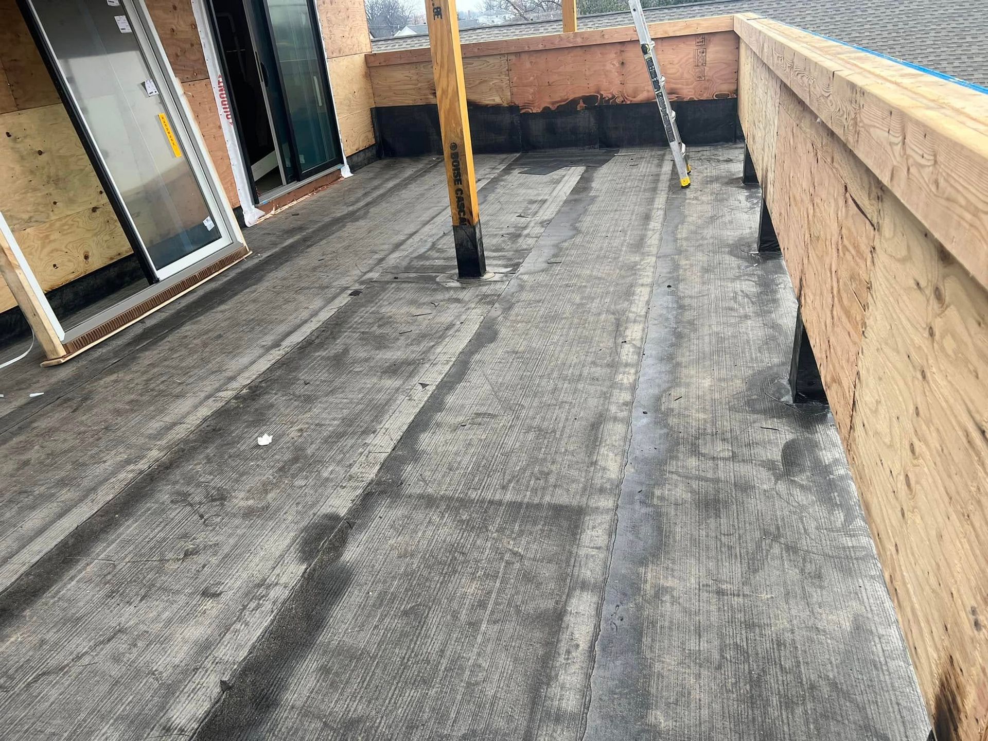 A rooftop with wooden beams and a waterproof membrane.