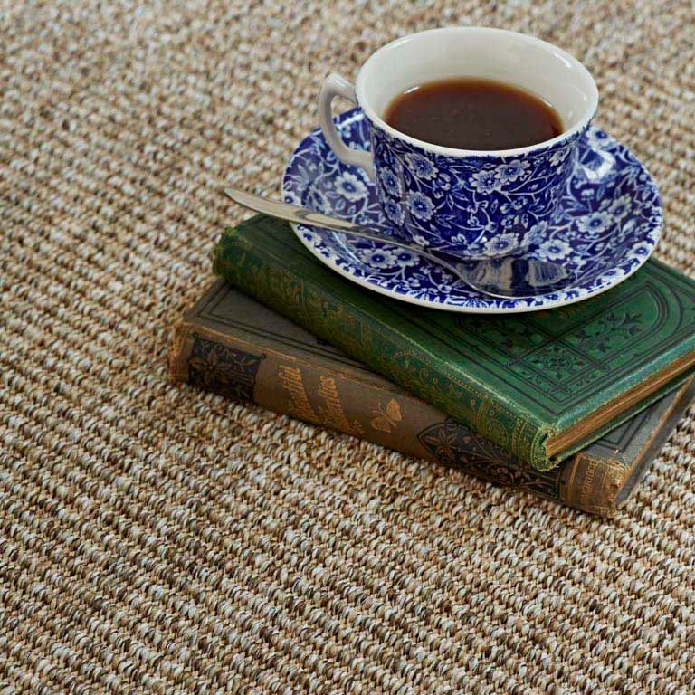 A cup of coffee is sitting on top of a stack of books.