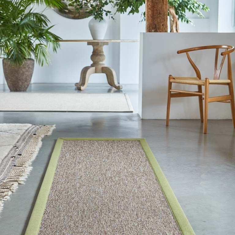 A living room with a table and chairs and a rug