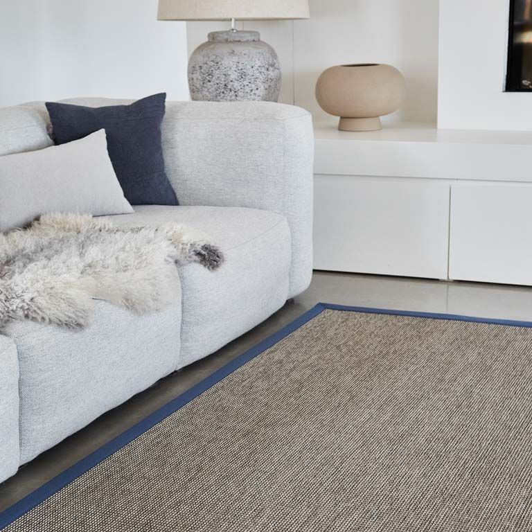 A living room with a white couch and a rug