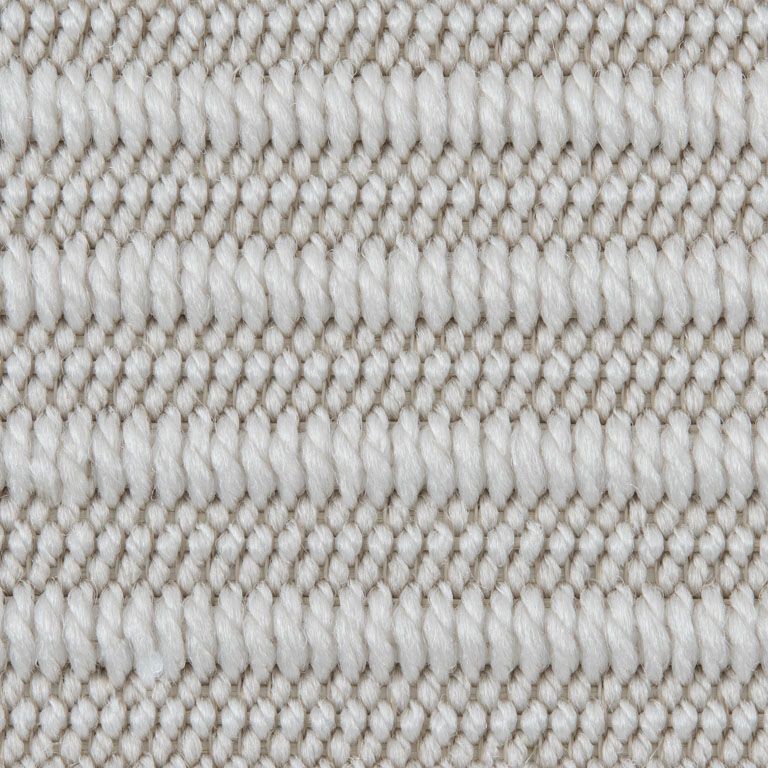 A close up of a white knitted fabric with a pattern.