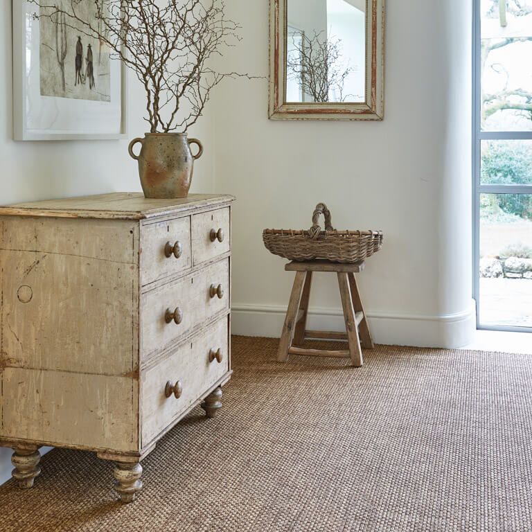 A dresser with a vase of branches on top of it