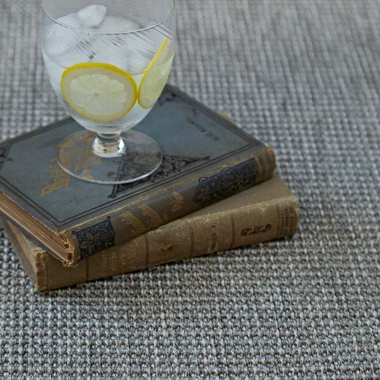 A glass of water with lemon slices is sitting on top of a stack of books.