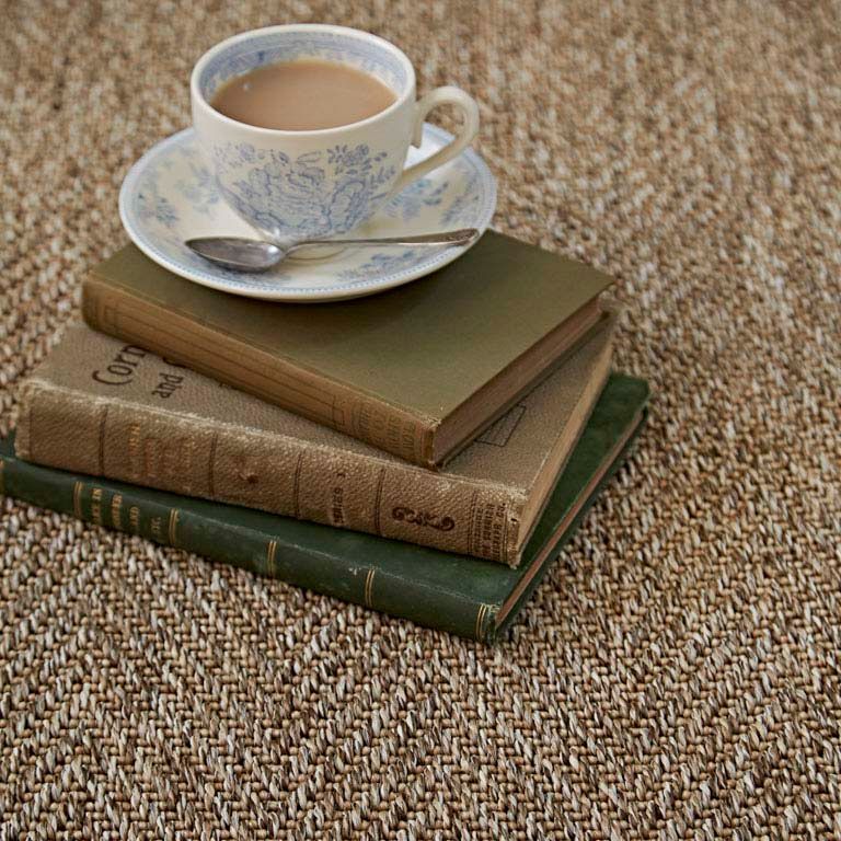 A cup of coffee sits on top of a stack of books