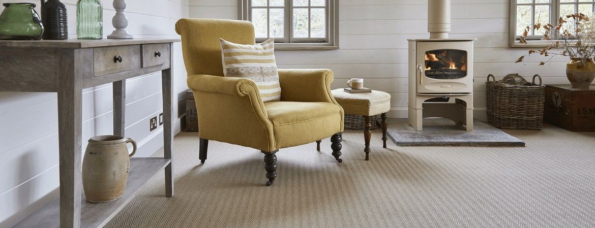 A living room with a yellow chair and a fireplace.