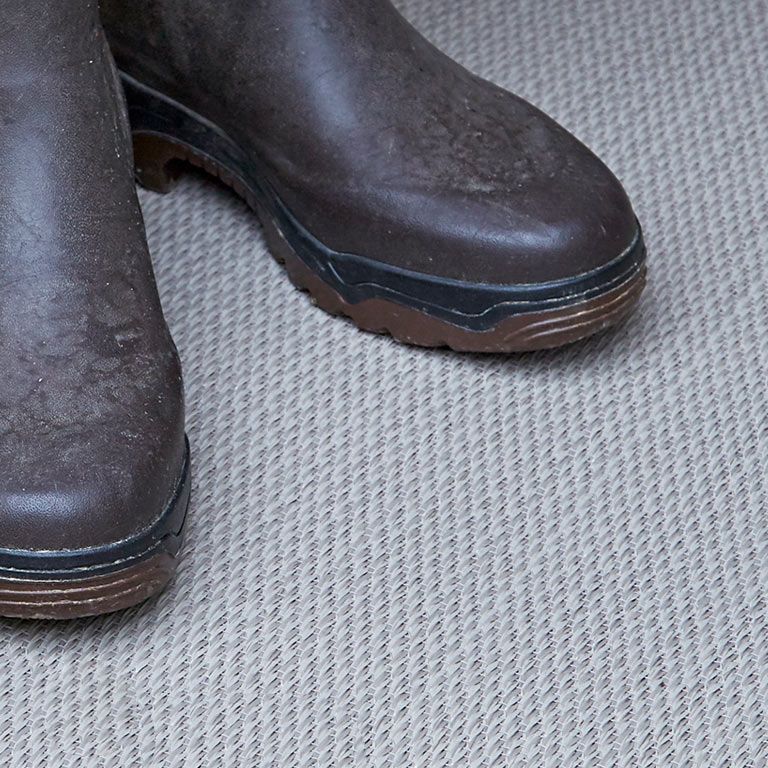 A pair of brown boots are sitting on a carpet.