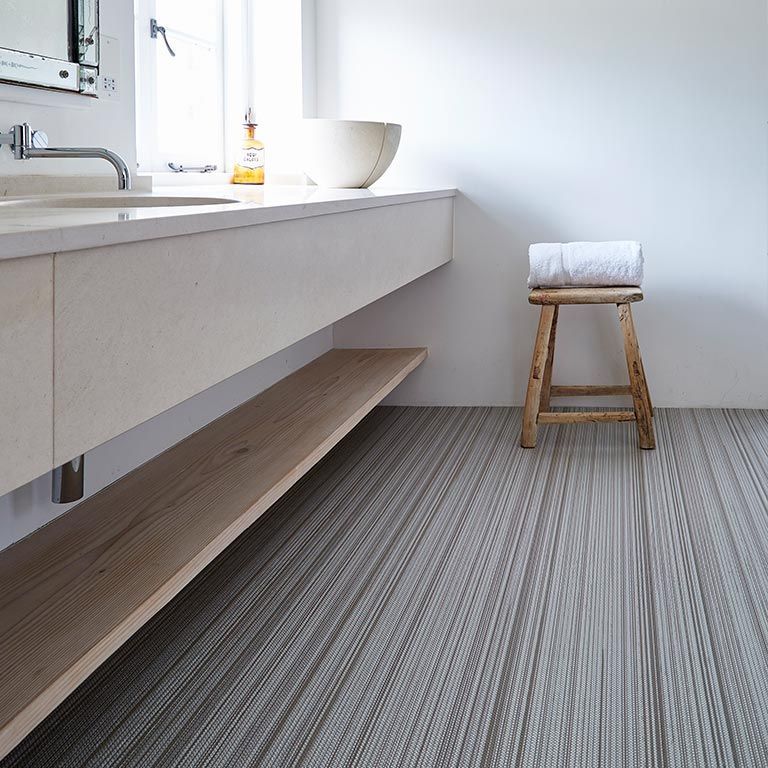 A bathroom with a sink and a wooden stool