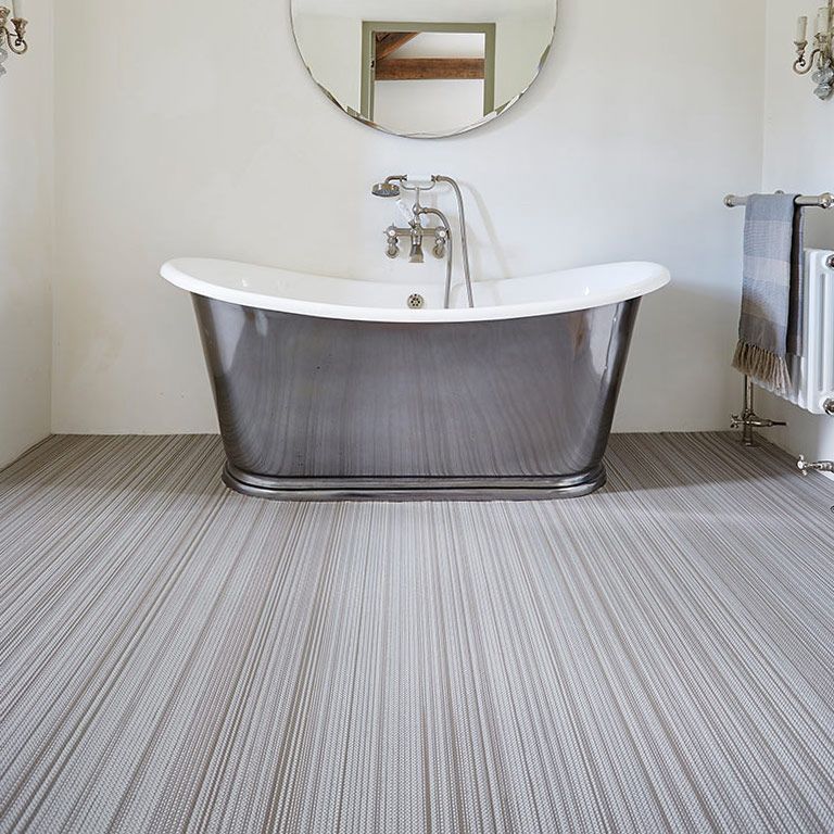 A bathroom with a bathtub and a mirror on the wall