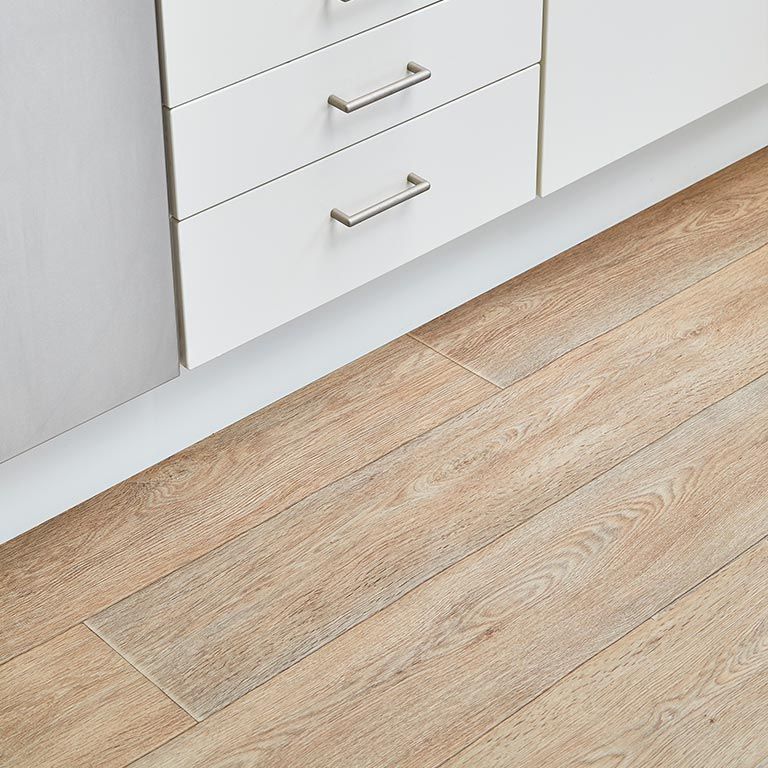 A kitchen with a wooden floor and white cabinets