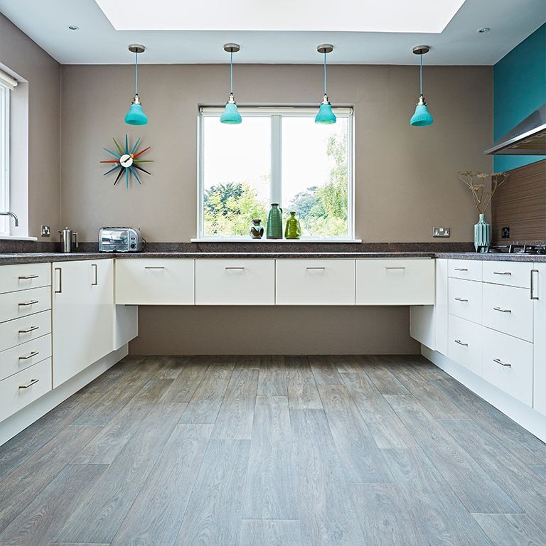 A kitchen with white cabinets and a clock on the wall