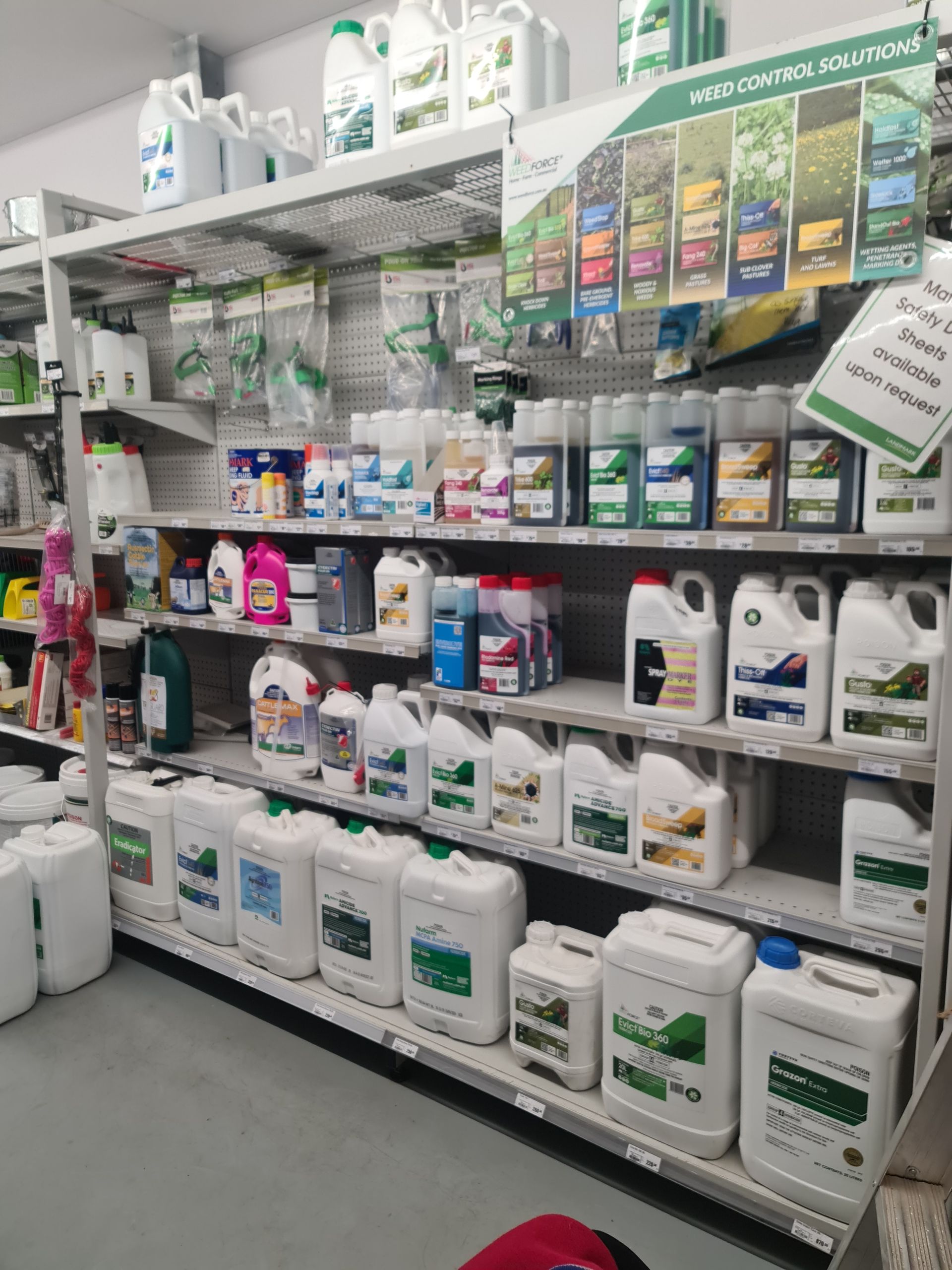 A blue tractor is plowing a field with a plow attached to it.