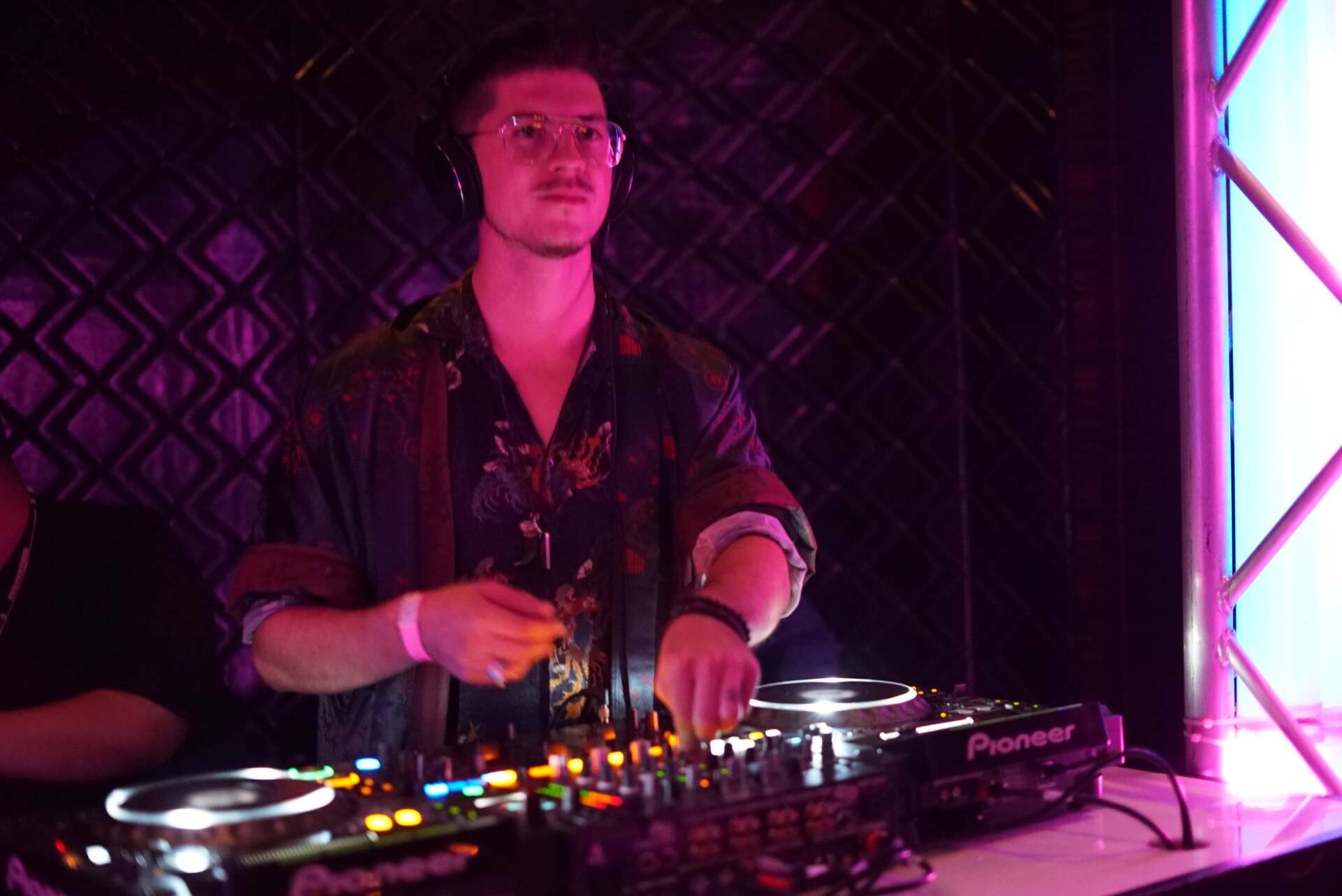 a man is playing a dj set in a dark room .