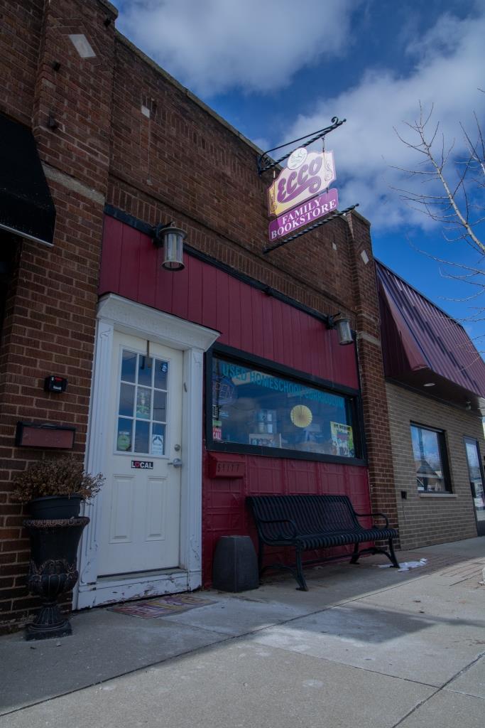 A red brick building with a sign that says 'Ecco' on it.