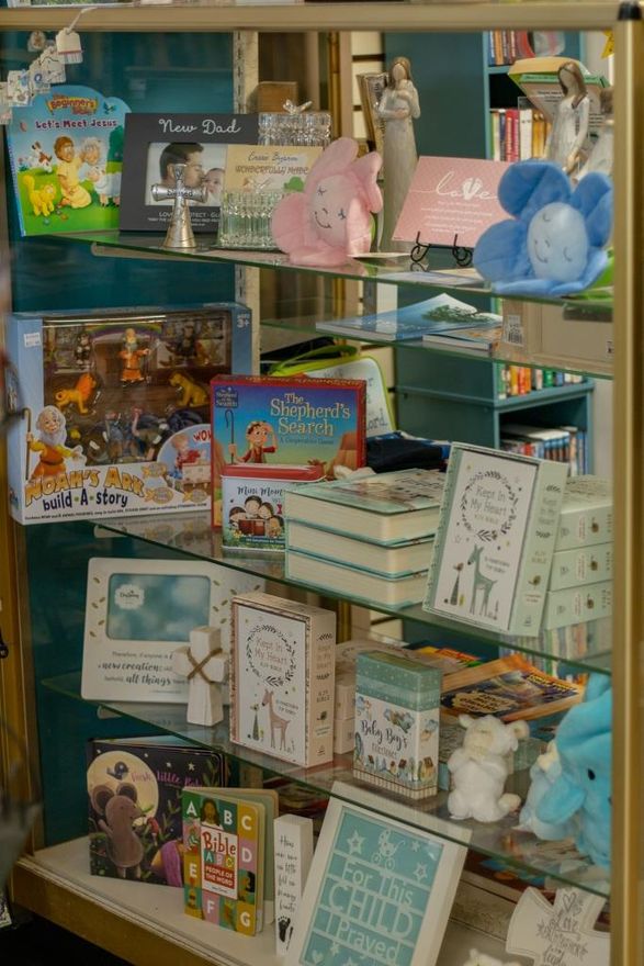A display case filled with books and toys including one that says 'I love you' on it.
