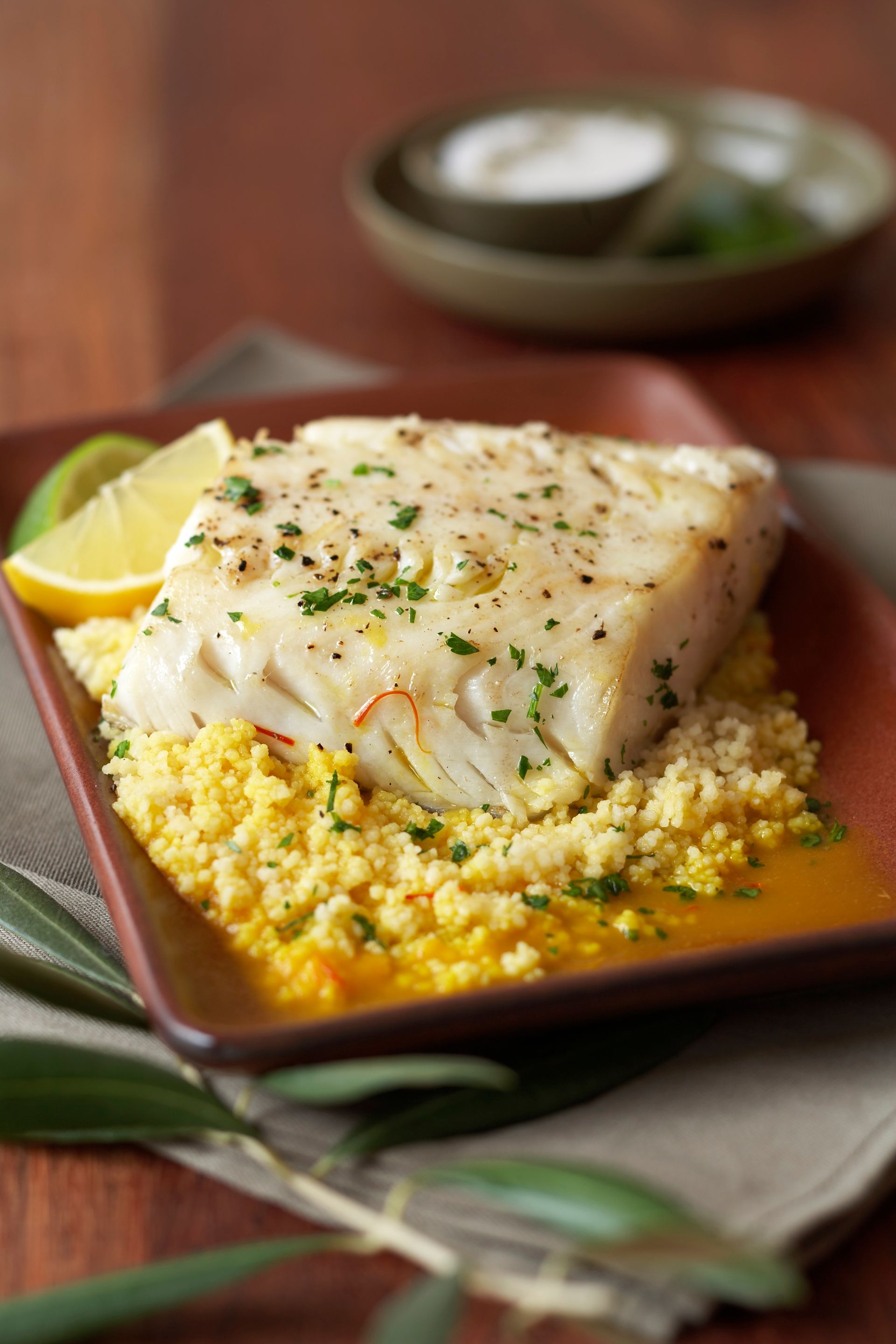 A close up of a plate of food with rice and fish on a table.