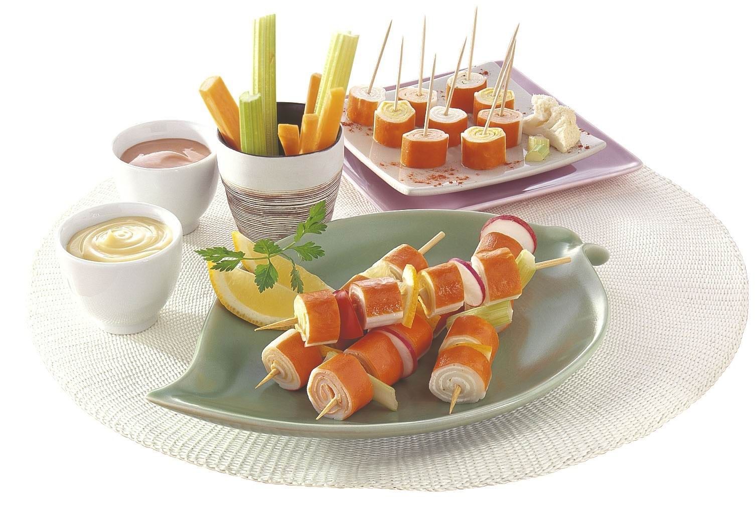 A plate of food on a table with a bowl of carrots and celery sticks
