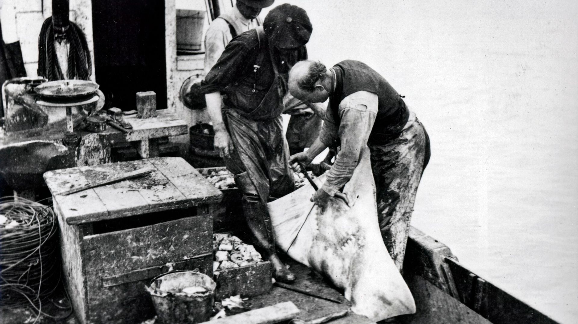 A black and white photo of two men in a boat
