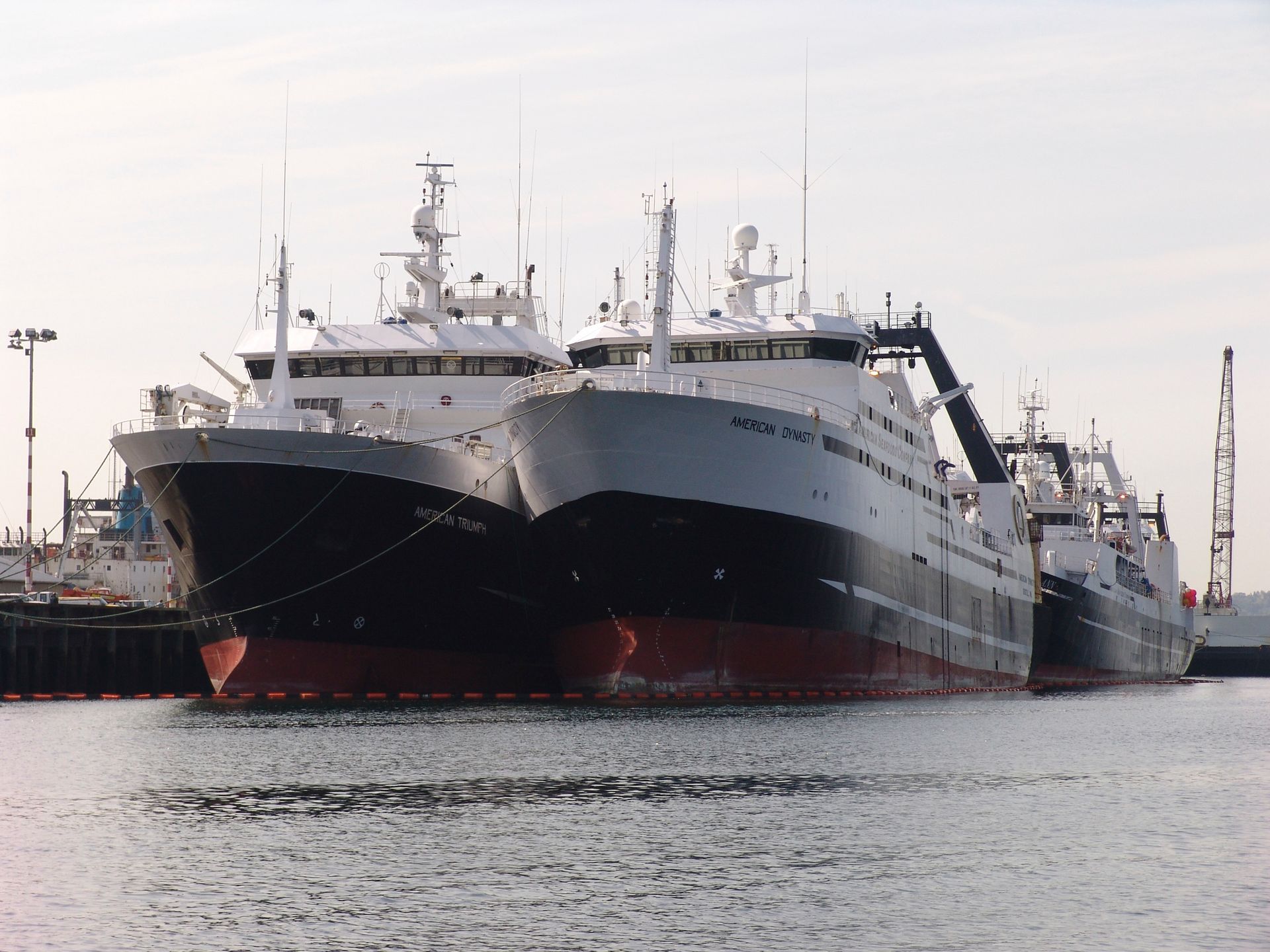 Two large ships are docked next to each other in the water