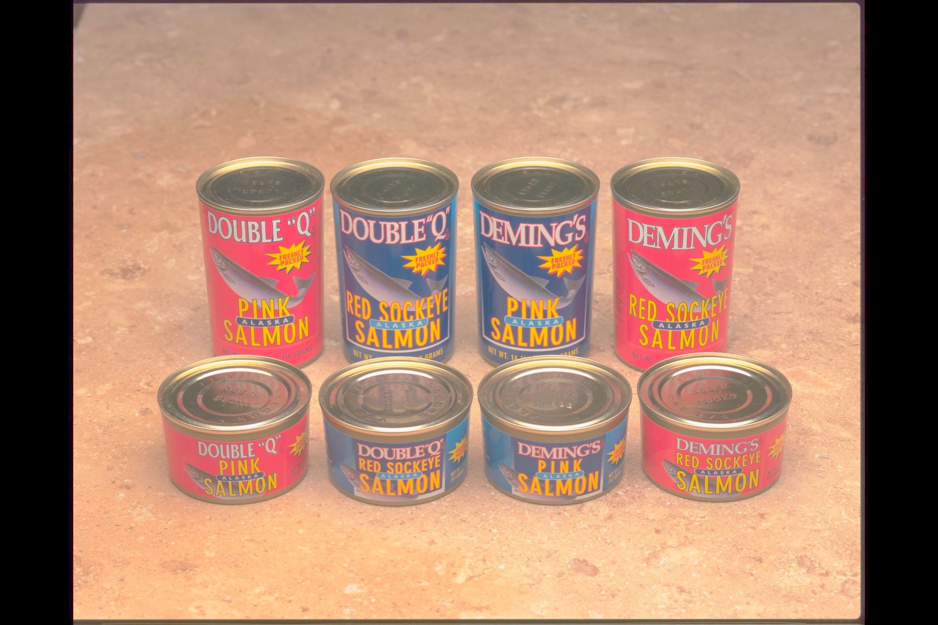 A group of cans of salmon are lined up on a table.