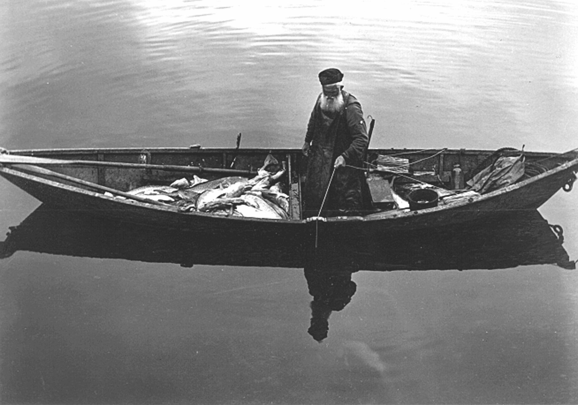 A black and white photo of a man in a boat
