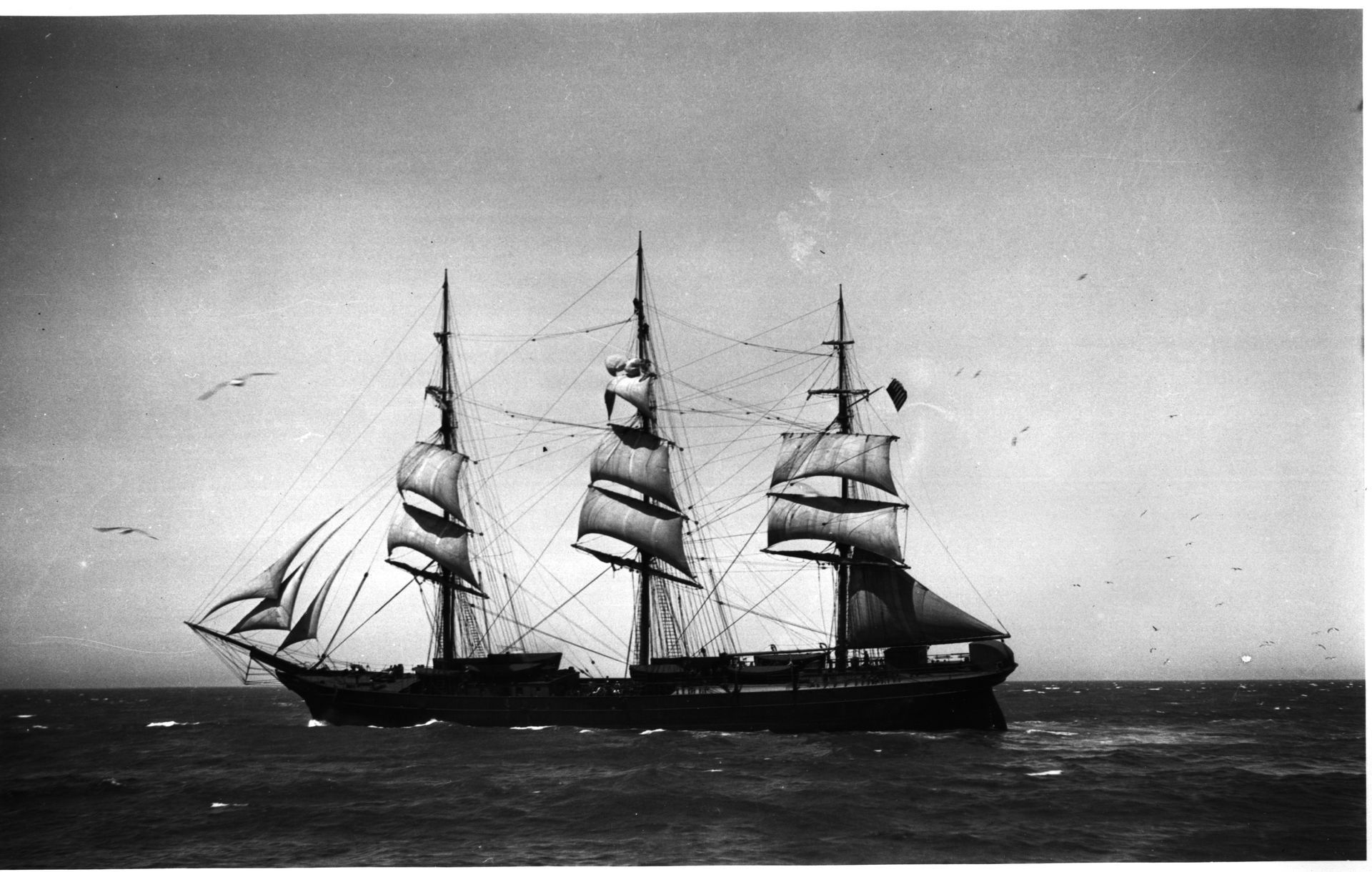 A black and white photo of a sailboat in the ocean