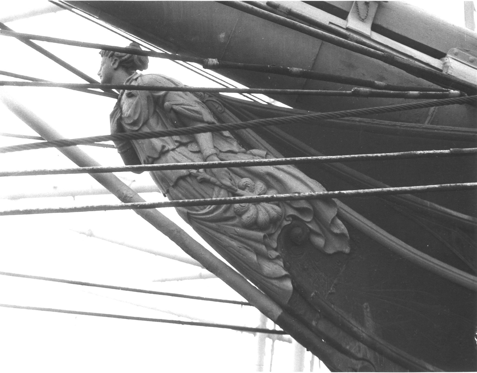 A black and white photo of a statue on the side of a ship