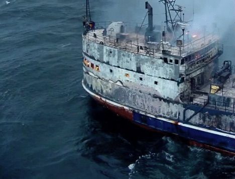 A large boat is floating on top of a body of water.