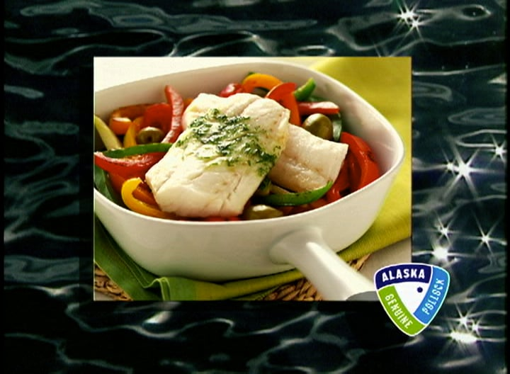 A white bowl filled with fish and vegetables with alaska written on the bottom